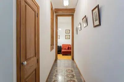 a hallway with a door and a red chair at Canela Homes BARCELONA JOVELLANOS in Barcelona