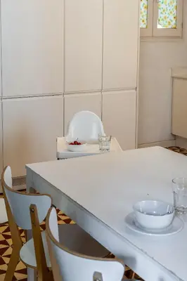 a kitchen with a white counter and chairs at Canela Homes BARCELONA ESSENCE in Barcelona