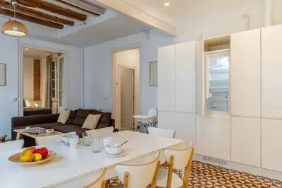 a kitchen and living room with a white table and chairs at Canela Homes BARCELONA ESSENCE in Barcelona