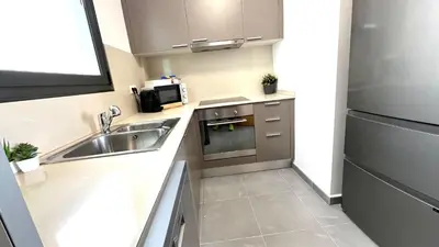 a small kitchen with a sink and a microwave at APARTAMENTO CON TERRAZA BY PRESTIGI in Terrassa