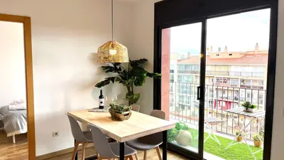 a dining room with a table and a large window at APARTAMENTO CON TERRAZA BY PRESTIGI in Terrassa