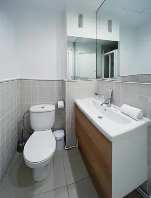 a bathroom with a toilet and a sink and a mirror at Stay U-nique Apartment General Mitre in Barcelona