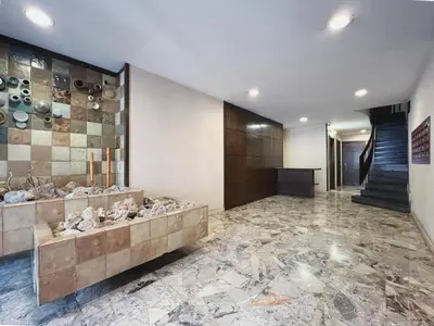 a lobby with a stone floor and a staircase at Stay U-nique Apartment General Mitre in Barcelona