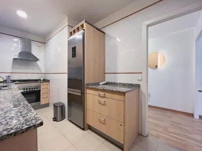a kitchen with a refrigerator and a counter top at Stay U-nique Apartment General Mitre in Barcelona