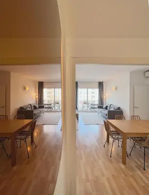 a living room with tables and chairs and a living room at Stay U-nique Apartment General Mitre in Barcelona
