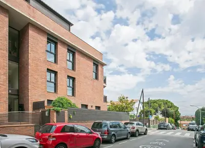 a group of cars parked in front of a brick building at Winahost La Terraza de Sant Cugat in Sant Cugat del Vallès