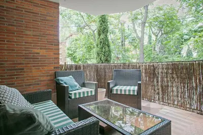 a patio with chairs and tables and a fence at Winahost La Terraza de Sant Cugat in Sant Cugat del Vallès