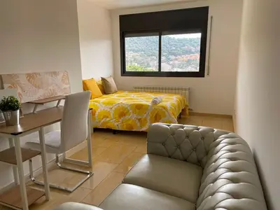 a bedroom with a bed and a table and a couch at Habitaciones en Villa Coliving Villa Vistas in San Fausto de Campcentellas