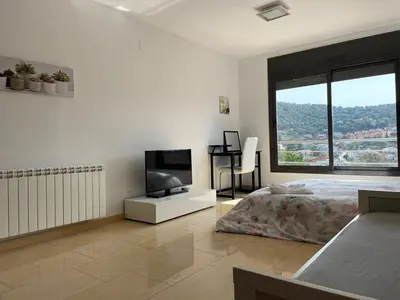 a bedroom with a bed and a flat screen tv at Habitaciones en Villa Coliving Villa Vistas in San Fausto de Campcentellas