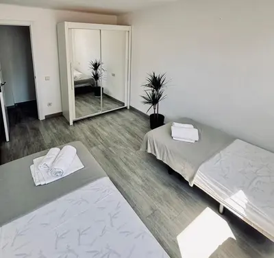 a room with two beds and a mirror at Apartamento Forum in Barcelona