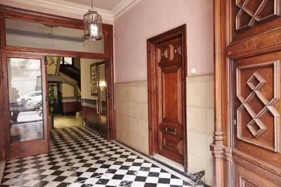 a hallway with a door and a checkered floor at Close to Passeig de Gracia in Barcelona