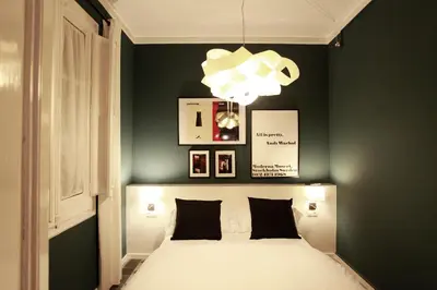 a bedroom with a bed with black walls and a chandelier at Close to Passeig de Gracia in Barcelona