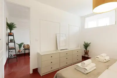 a white bedroom with a dresser with towels on it at Sagrada Familia Vl by Enjoy Apartments in Barcelona