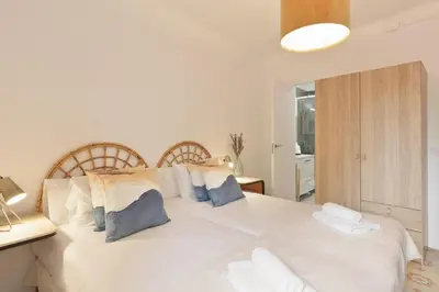 a bedroom with a large white bed with blue pillows at Sagrada Familia Vl by Enjoy Apartments in Barcelona