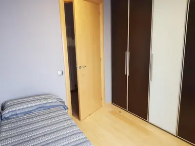 a bedroom with a bed and a door to a closet at Pis de bon disseny i sostenible. in Manresa