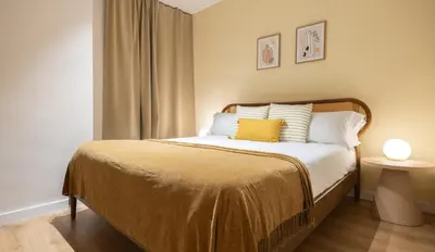 a bedroom with a bed with a yellow pillow on it at Stay U-nique Apartments Balmes II in Barcelona