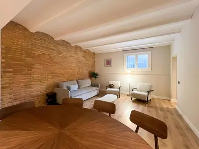 a living room with a couch and a brick wall at Stay U-nique Apartments Balmes II in Barcelona