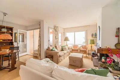 a living room with white couches and a table at Piso con vista increíble al mar in Sant Andreu de Llavaneres