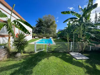 a fence in front of a yard with a pool at VILLA MasÍa CAL TONI in Pineda de Mar