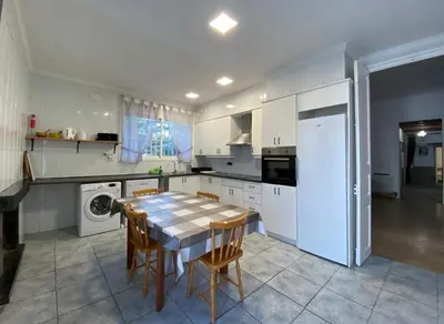 a kitchen with a table and chairs and a refrigerator at VILLA MasÍa CAL TONI in Pineda de Mar