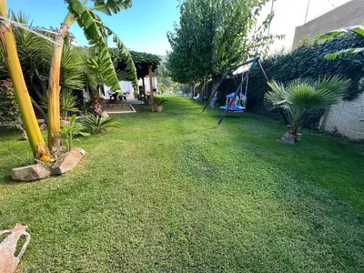 a yard with a hammock and a swing at VILLA MasÍa CAL TONI in Pineda de Mar