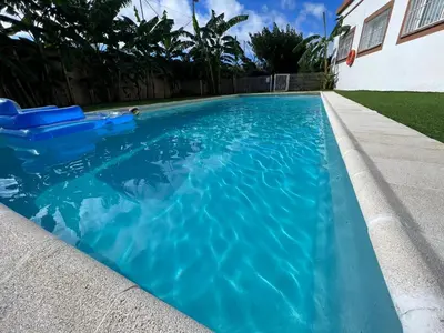 a swimming pool with blue water in a yard at VILLA MasÍa CAL TONI in Pineda de Mar