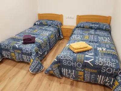 two beds sitting next to each other in a room at Pis clar i espaiós in Manresa