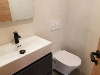 a bathroom with a white sink and a toilet at Pis clar i espaiós in Manresa