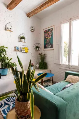 a living room with a couch and a potted plant at Enchanting 2 BR flat with terrace near Plaça Espanya in Barcelona