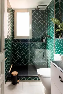 a bathroom with green tiled walls and a toilet at Enchanting 2 BR flat with terrace near Plaça Espanya in Barcelona