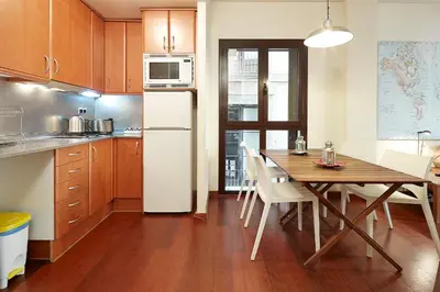 a kitchen with a table and a white refrigerator at Olles Apartment in Barcelona