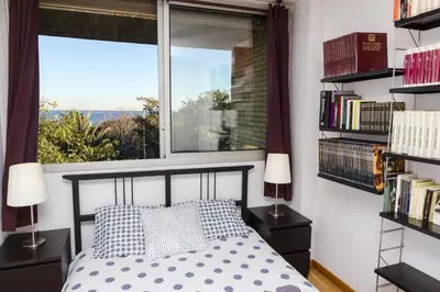 a bedroom with a bed and a window and bookshelves at Vila Olimpica Skyline in Barcelona