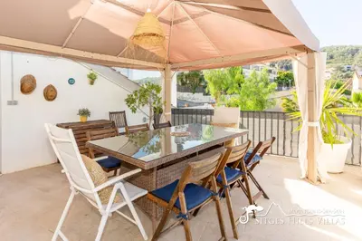 a patio with a table and chairs and a pool at Beautiful Villa Encanto with private pool in Olivella