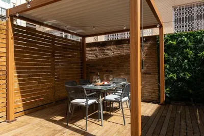 a patio with a table and chairs on a wooden deck at Lodging Apartments Rambla Poblenou 12 in Barcelona