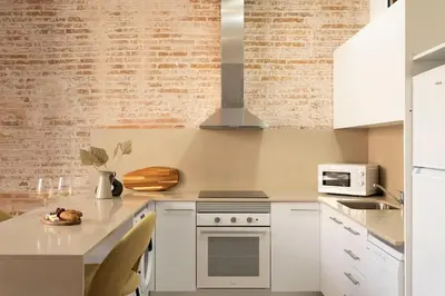 a kitchen with white cabinets and a stove top oven at Lodging Apartments Rambla Poblenou 12 in Barcelona
