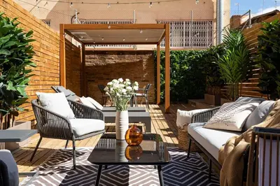 a patio with a couch and chairs and a table at Lodging Apartments Rambla Poblenou 12 in Barcelona