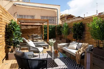 a patio with a couch and chairs and a table at Lodging Apartments Rambla Poblenou 12 in Barcelona