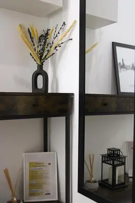 a mirror on a shelf with a vase of flowers at Apartamento Lauda in Hospitalet de Llobregat