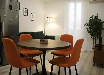 a dining room with a table and orange chairs at Apartamento Lauda in Hospitalet de Llobregat