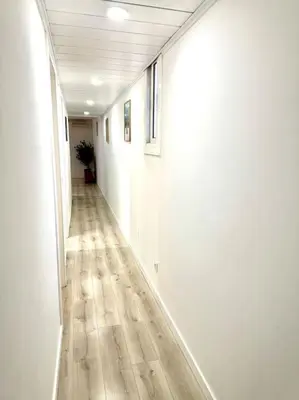 an empty hallway with white walls and wooden floors at Apartamento Lauda in Hospitalet de Llobregat