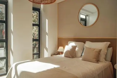 a bedroom with a white bed with a mirror on the wall at Casa Macaya - 1b apartment in Eixample in Barcelona