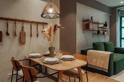 a dining room with a table and a green couch at Casa Macaya - 1b apartment in Eixample in Barcelona