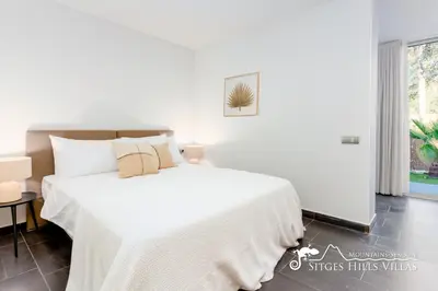 two beds in a bedroom with white walls at Stunning Villa Angeles with Private Pool and AC close to Sitges in Olivella