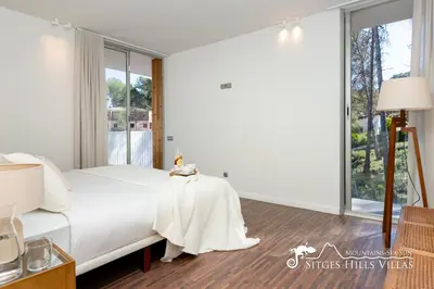 a bedroom with a white bed and a window at Stunning Villa Angeles with Private Pool and AC close to Sitges in Olivella