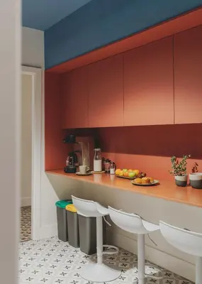 a kitchen with red cabinets and a counter with chairs at Piulet Hostel in Barcelona