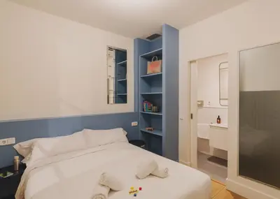 a bedroom with a white bed and a blue wall at Piulet Hostel in Barcelona
