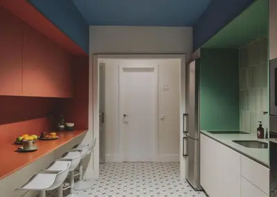 a kitchen with red and green walls and white cabinets at Piulet Hostel in Barcelona