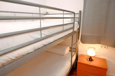 a small room with a bed and a nightstand and a window at Homenfun Barcelona Eixample ll in Barcelona