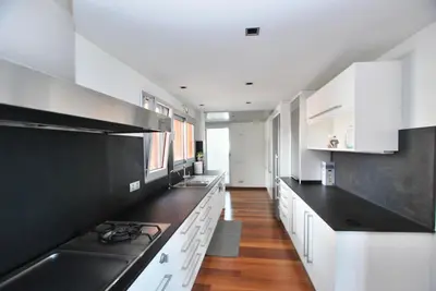 a kitchen with white cabinets and black counter tops at Picasso Street in Vilassar de Mar