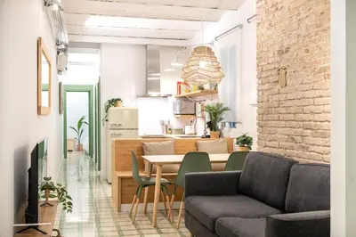 a living room and kitchen with a table and chairs at Charming renovated Apt minutes from the center in Barcelona